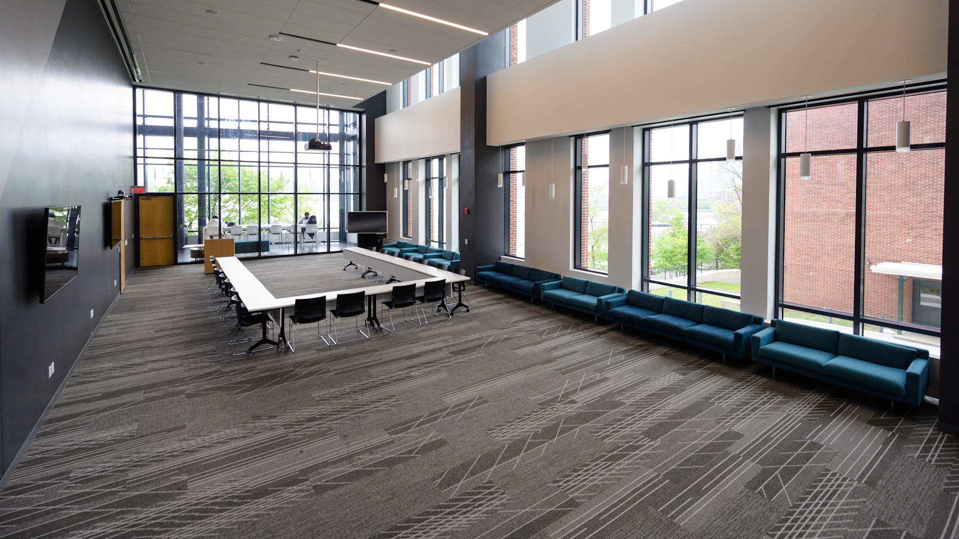 The University Center conference room set as a square table, with double-height windows onto the campus